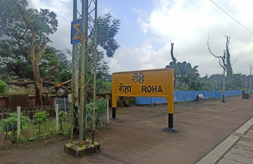 Roha_a yellow street sign sitting on the side of a road